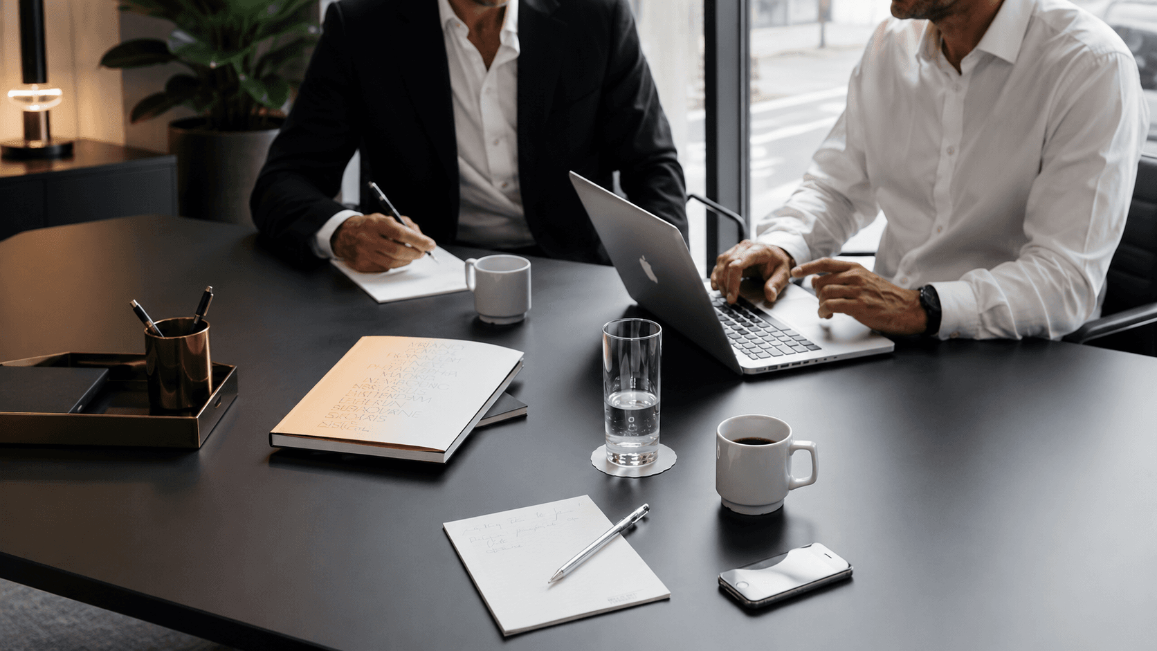 Two colleagues reviewing notes at a meeting table